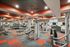 Modern fitness center with state-of-the-art gym equipment, colorful flooring, and stylish ceiling design.