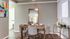 Chic dining area with modern table setting, elegant wall art, and warm natural lighting.