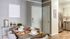 Chic dining area with modern decor, set for four, adjacent to a sleek, well-equipped kitchen.