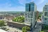 Modern high-rise apartment building with sleek architecture, offering stunning city and park views, surrounded by greenery and vibrant urban life.