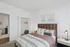 Contemporary bedroom with elegant decor, featuring a plush queen-sized bed, spacious closet, and soft lighting creating a warm and inviting atmosphere.