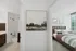 Modern apartment interior showcasing a stylish bathroom with contemporary fixtures and a cozy bedroom featuring a large window for natural light.