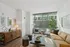 Bright, modern living room with floor-to-ceiling windows, elegant decor, and cozy seating in a stylish apartment.