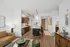 Chic open-concept living space with modern kitchen, elegant dining area, and cozy seating, featuring stylish decor and rich wood finishes.