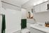 Bright, modern bathroom with sleek fixtures, elegant vanity, and contemporary artwork, creating a serene oasis.