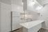 Modern kitchen featuring sleek white cabinetry, a spacious countertop, and contemporary lighting fixtures.