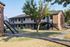 Charming two-story apartment building with brick facade, surrounded by lush greenery and convenient stair access.