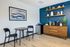 Chic modern corner with a cozy table set, elegant shelving, and a stylish coffee station, perfect for relaxing moments.