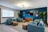 Inviting living room featuring stylish blue sofas, modern decor, and a large flat-screen TV, perfect for relaxation and entertainment.