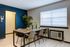 Modern dining area with a sleek wooden table, comfortable chairs, green plant decor, and large window for natural light.