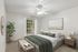 Inviting bedroom with modern decor, featuring a plush bed, stylish artwork, and natural light through a large window.