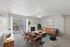 Bright and modern living room with plush carpet, cozy fireplace, and stylish seating area, enhanced by natural light from floor-to-ceiling sliding doors.