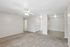 Spacious apartment featuring a cozy carpeted living area, elegant ceiling fan, and versatile neutral tones, perfect for modern living.