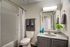 Bright and modern bathroom featuring a sleek vanity mirror, elegant white countertop, stylish striped shower curtain, and fresh plant decor.