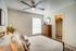 Inviting bedroom with modern ceiling fan, elegant decor, and a spacious walk-in closet for convenient storage.