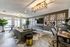 Modern apartment lounge area with contemporary decor, vibrant abstract art, and ample natural light through large windows.