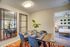 Inviting open dining area with elegant mirrors, vibrant decor, and a glimpse into a cozy bedroom with modern accents.