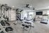 Modern apartment gym with diverse workout equipment including treadmills, weight machines, and a TRX training zone for a complete fitness experience.