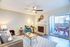 Inviting living room with modern decor, featuring a cozy fireplace, plush seating, and access to a private balcony.
