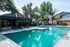 Luxurious outdoor pool area surrounded by lush greenery and elegant seating, perfect for relaxation and entertainment.