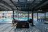 Modern outdoor seating area under pergola next to inviting pool, surrounded by stylish apartment buildings and loungers.