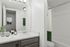 Sleek and modern bathroom with elegant white finishes, stylish granite countertop, and a cozy tub for relaxation.