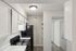 Modern kitchen with sleek black appliances, ample cabinetry, and elegant shelving, perfect for urban living.