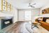 Modern living room with cozy fireplace, stylish artwork, and elegant brown sofa, perfect for relaxation.