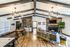 Chic open-concept living space with high ceilings, modern lighting fixtures, stylish wood flooring, and elegant furnishings.