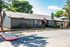Inviting leasing office with modern siding, vibrant landscaping, and an American flag gracing the entrance.