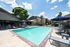Inviting swimming pool area surrounded by comfortable lounge chairs and umbrellas, perfect for relaxation on a sunny day.