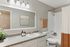 Contemporary bathroom with elegant vanity, large mirror, and stylish decor.