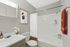 Chic modern bathroom with elegant fixtures, vibrant artwork, and lush greenery creating a serene and inviting atmosphere.