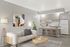 Contemporary apartment living area featuring a stylish sofa, modern art, and a chic kitchen with bar stools, perfect for urban living.