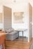 Elegant seating area at ReNew Howard Crossing with modern partition design, featuring a cozy gray sofa and stylish wooden tables, complemented by abstract wall art.