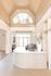 Elegant apartment lobby at ReNew Howard Crossing with high vaulted ceilings, sophisticated lighting, and a modern reception desk adorned with a stylish floral arrangement.