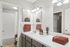 Elegant modern bathroom with a speckled countertop, chic lighting, artful wall decor, and plush towels.