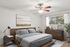 Inviting bedroom with elegant decor, featuring a cozy bed, wooden furniture, and large window for natural light.