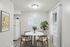 Chic dining area with a round marble table, modern wooden chairs, and vibrant wall art for a stylish touch.