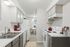 Charming galley kitchen with modern appliances, sleek countertops, and a cozy dining area with natural light.