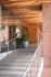 Elegant apartment entrance featuring modern glass doors, sleek wooden ceilings, and lush potted plants, exuding a welcoming and contemporary ambiance.