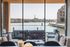 Luxurious waterfront apartment with stylish seating area overlooking scenic views of the river and cityscape.