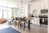 Contemporary open-concept kitchen and living area with stylish decor, featuring a cozy seating arrangement, chic lighting, and modern appliances.