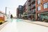 Modern apartment complex featuring a luxurious swimming pool, sun loungers, and stylish exterior design.