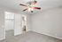 Bright bedroom with elegant ceiling fan, adjacent walk-in closet, and modern ensuite bathroom in a serene, neutral palette.