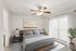 Modern bedroom with a cozy bed, stylish ceiling fan, and large window with natural light.