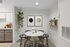 Cozy dining area with a round marble table, elegant black chairs, and modern decor, featuring a lush hanging plant and contemporary wall art.
