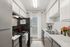 Charming kitchen with sleek countertops, modern appliances, and a sunlit window adorned with elegant curtains.