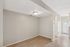 Inviting apartment interior with warm wooden flooring and soft natural lighting, featuring a cozy dining area adjacent to a walkway with modern finishes.