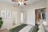Charming bedroom with cozy decor, showcasing a spacious closet with organized clothing, modern ceiling fan, and serene wall art accents.
